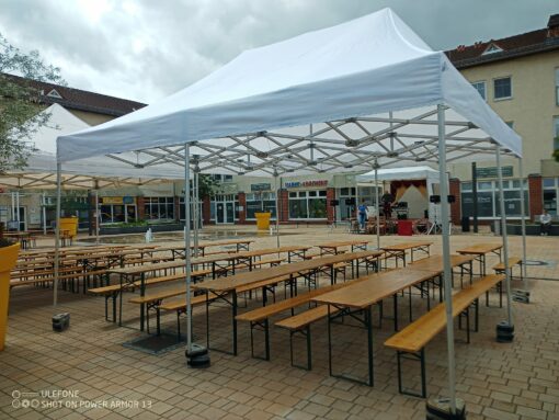 weißer Faltpavillon 5x5 Meter ohne Seitenwände mit Bierzeltgarnituren im Einsatz